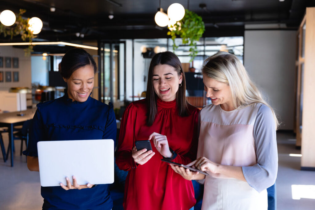 women-connect Three professional women looking at their phones and laptops